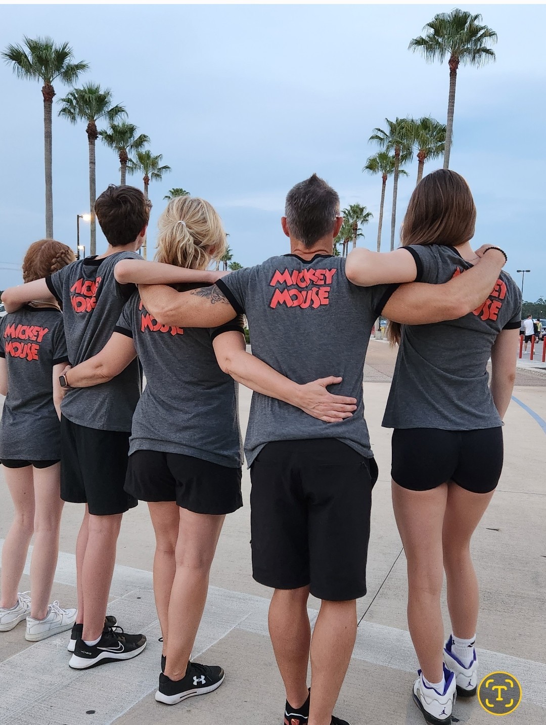 Family from behind at Disneyland wearing Mickey Mouse t-shirts