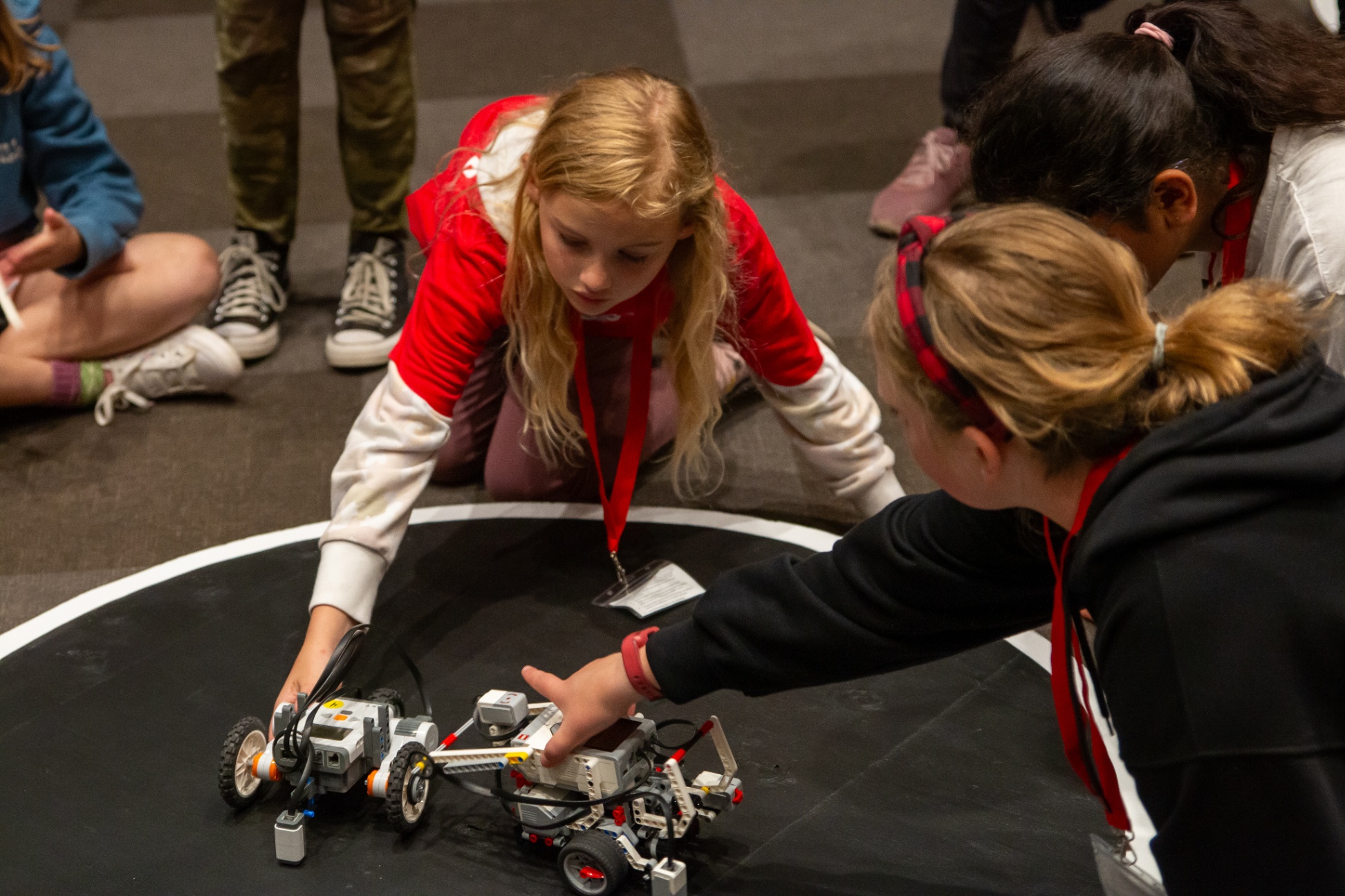 Students set their Lego robots up in the ring for a sumo style battle.